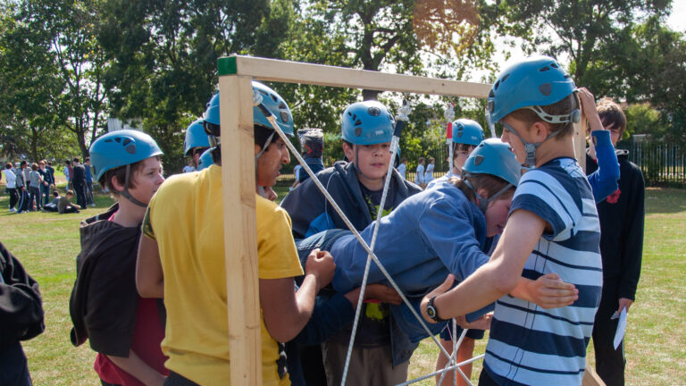 School children in Derbyshire collaborating in an outdoor team building challenge